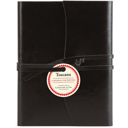 Black leather journal with a label on a white background