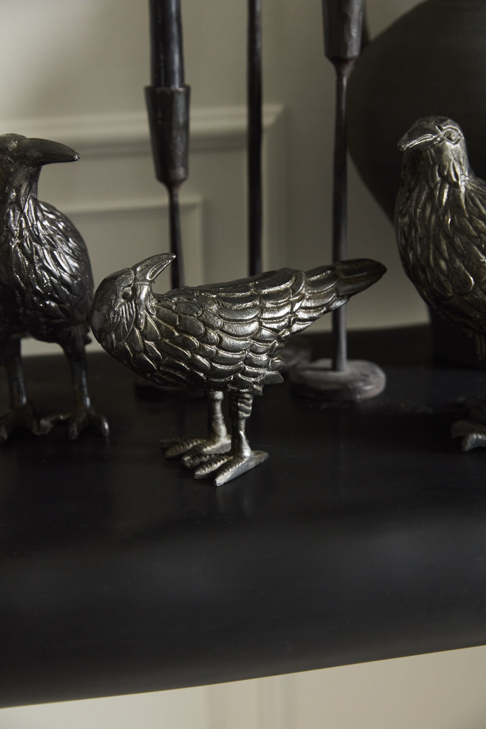 Decorative metal bird sculptures on a dark surface