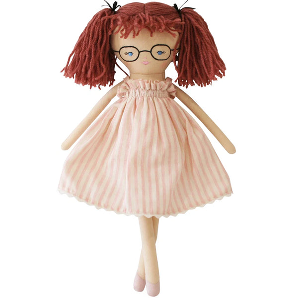 Doll with red hair in pigtails wearing a pink stripe dress on a white background