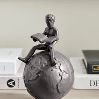 Brown Cast Iron Boy Reading on Globe Sculpture | Danya B.