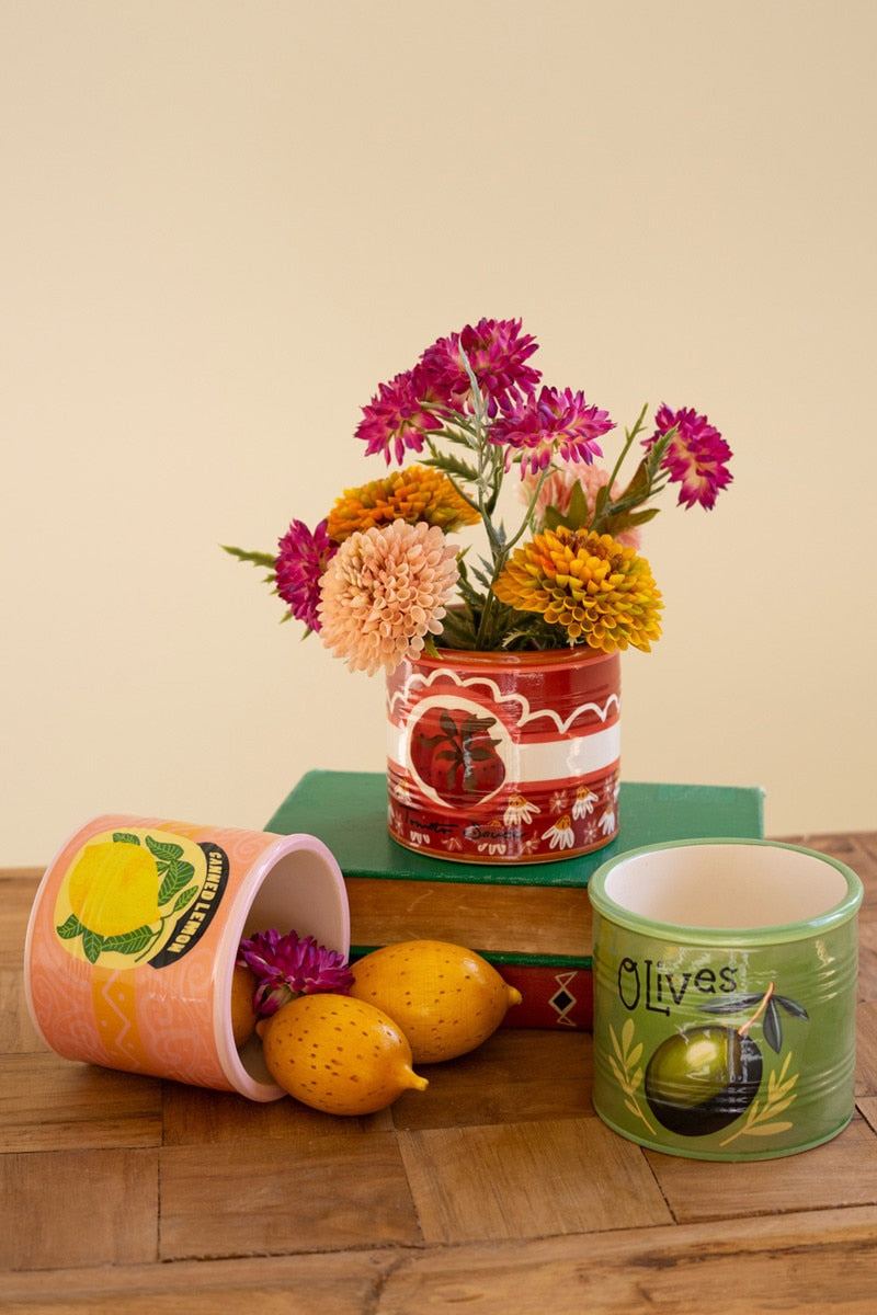 Decorative flower pots with floral arrangement on a wooden surface