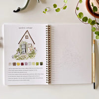Open notebook with garden-themed design and color swatches on a white surface.