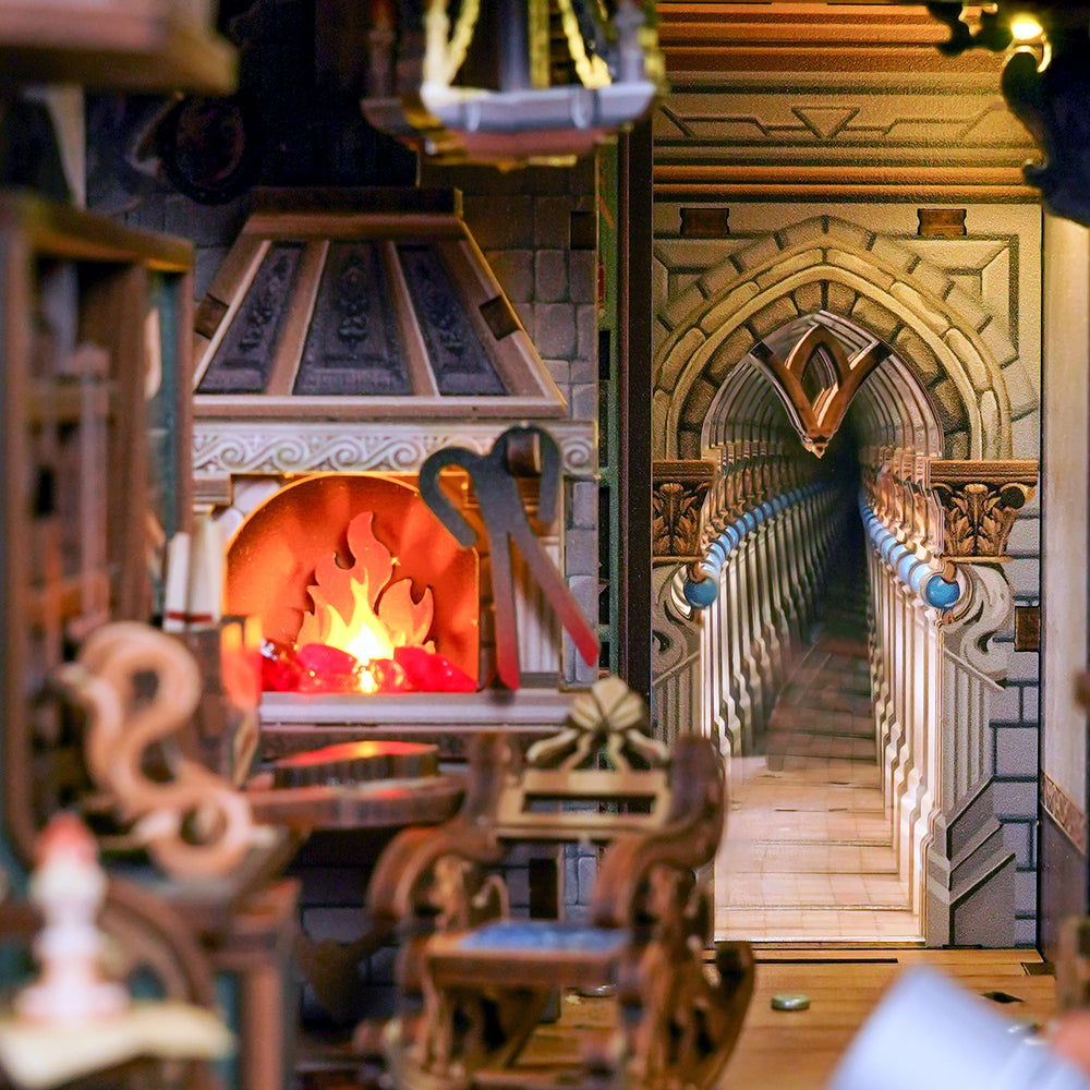 A miniature dollhouse interior scene with a detailed stone fireplace, glowing orange fire, carved wooden furniture, and a long arched staircase in the background.