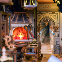 A miniature dollhouse interior scene with a detailed stone fireplace, glowing orange fire, carved wooden furniture, and a long arched staircase in the background.