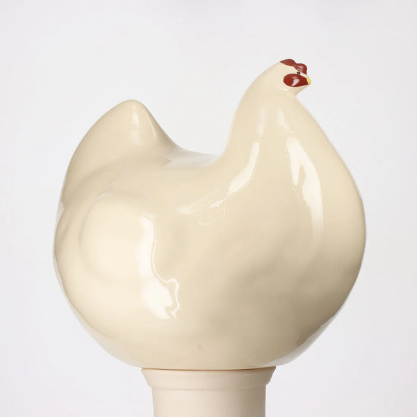 Beige ceramic chicken-shaped statue on a white background