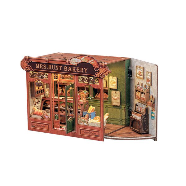 A miniature book nook model of 'Mrs. Hunt Bakery' with detailed interior scenes, miniature furniture, and decorative elements, shown against a plain white background.