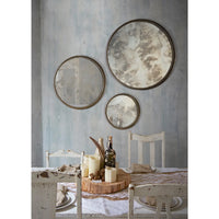 Dining room with round mirrors on the wall and a table set for a meal.