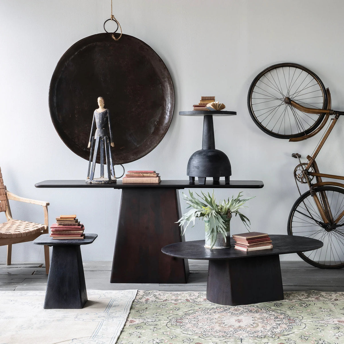 Modern interior with black tables, a bicycle, and decorative items.