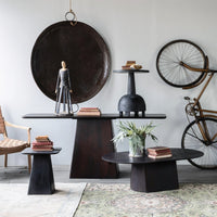 Modern interior with black tables, a bicycle, and decorative items.
