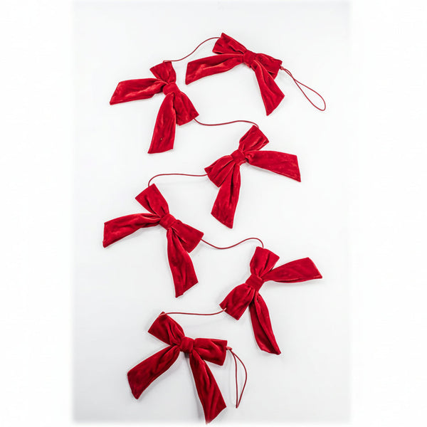 A red velvet bow garland made of five tied velvet bows connected by thin red strings, laid out on a plain white background.