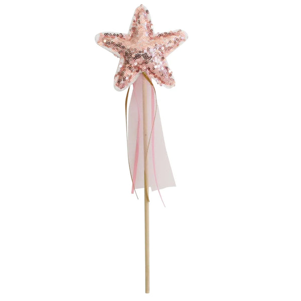 A children's star wand with a sequined star-shaped top in pale pink and rose gold, attached to a light wooden stick with two hanging ribbons, one pink and one white, on a plain white background.