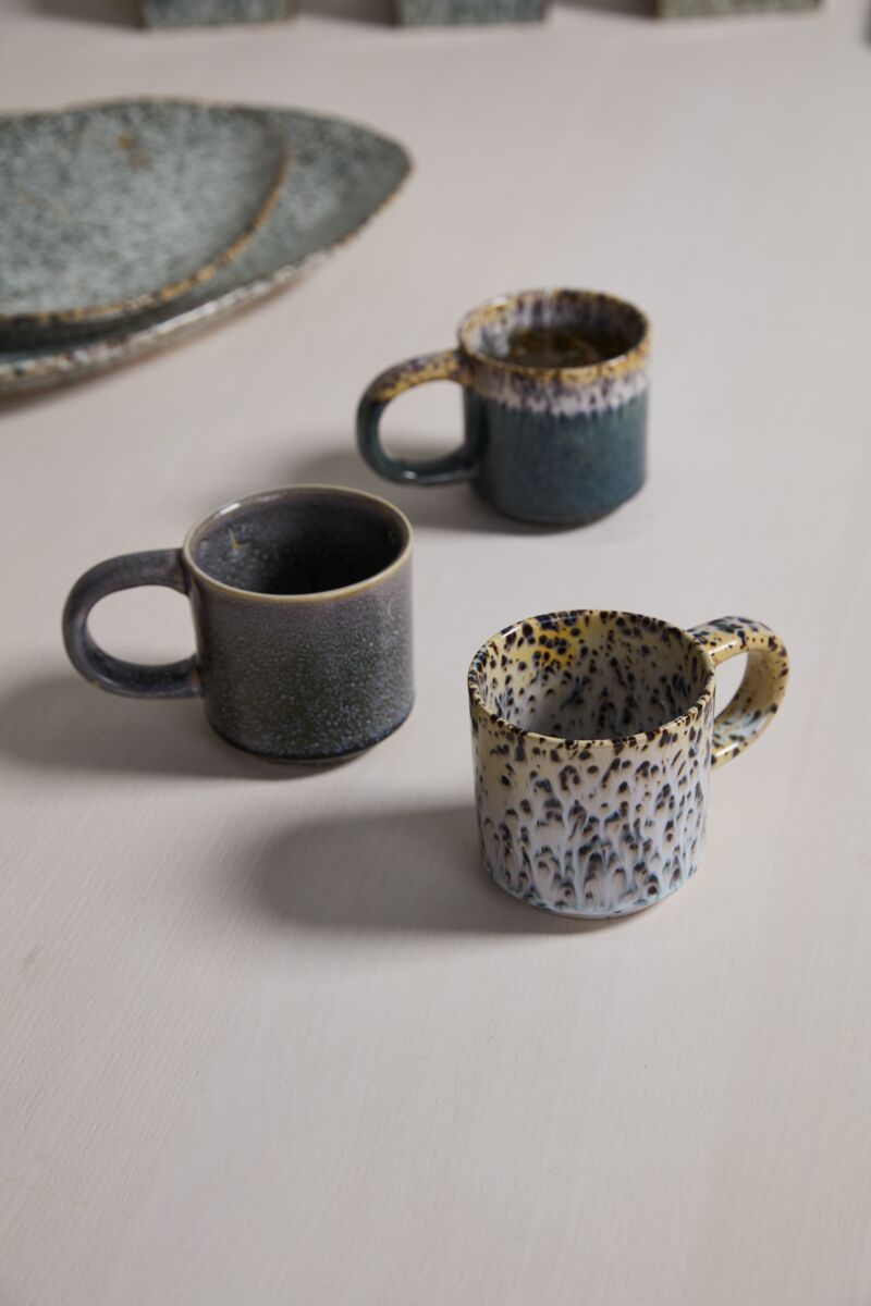 Three ceramic mugs with unique patterns on a light surface