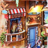 A detailed miniature diorama of a pirate-themed building with a striped awning labeled 'MASK', a blue door, ship's wheel decor, and small figurines including a pirate and a child.