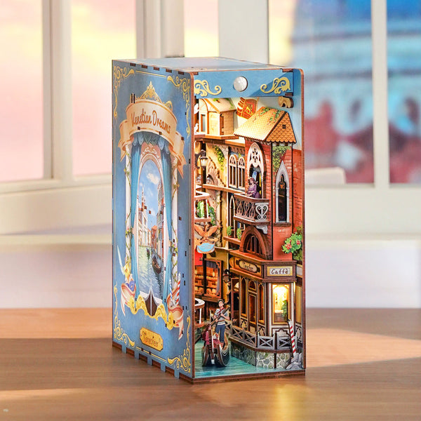 Boxed model kit of a detailed miniature house with a colorful design on a wooden surface.