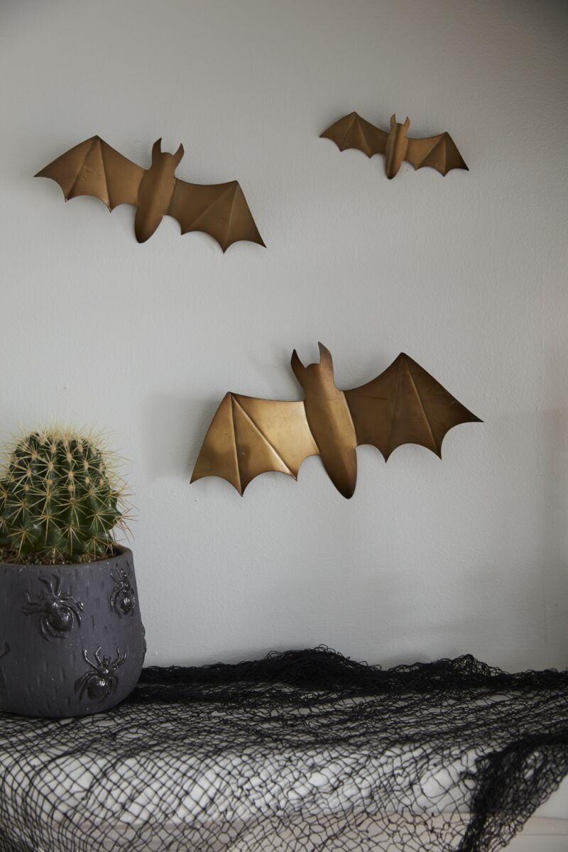 Three golden metal bats mounted to a wall.
