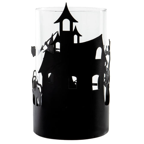 A clear cylindrical glass candle holder or vase featuring a black silhouette cutout of a haunted house with bats on the side, shown against a plain white background.